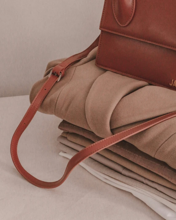 a bag is stacked on top of a pile of folded newspapers