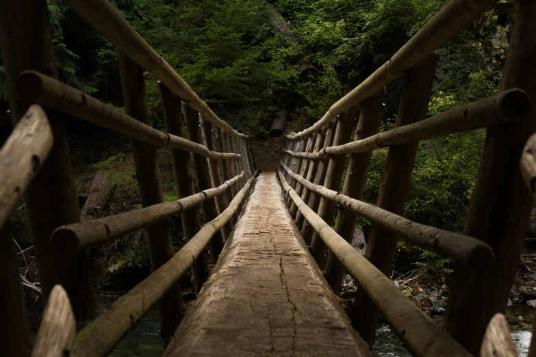 the wooden bridge crosses across a river that has no one on it