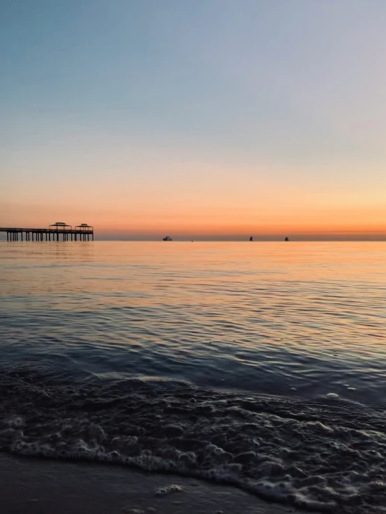 some boats on the water and an ocean at sunset