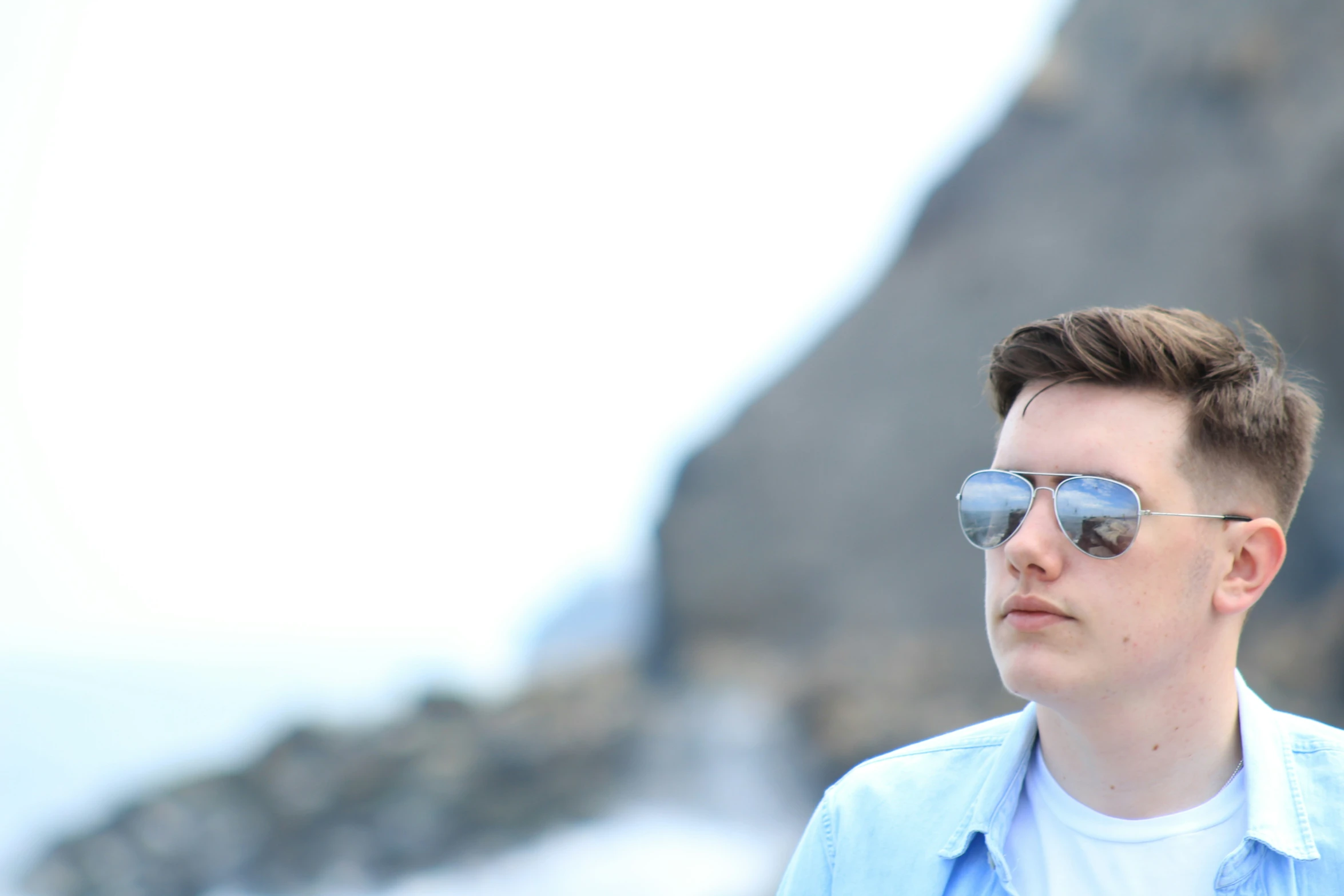 a man with a sunglasses standing in front of some water