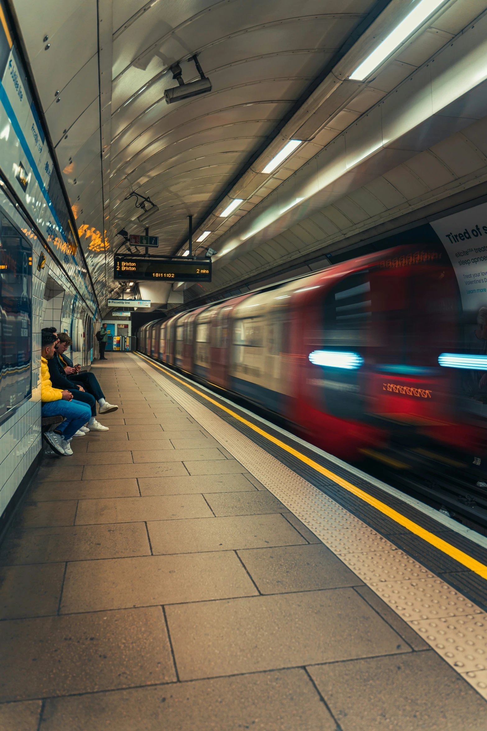 people are sitting at the platform waiting for the train