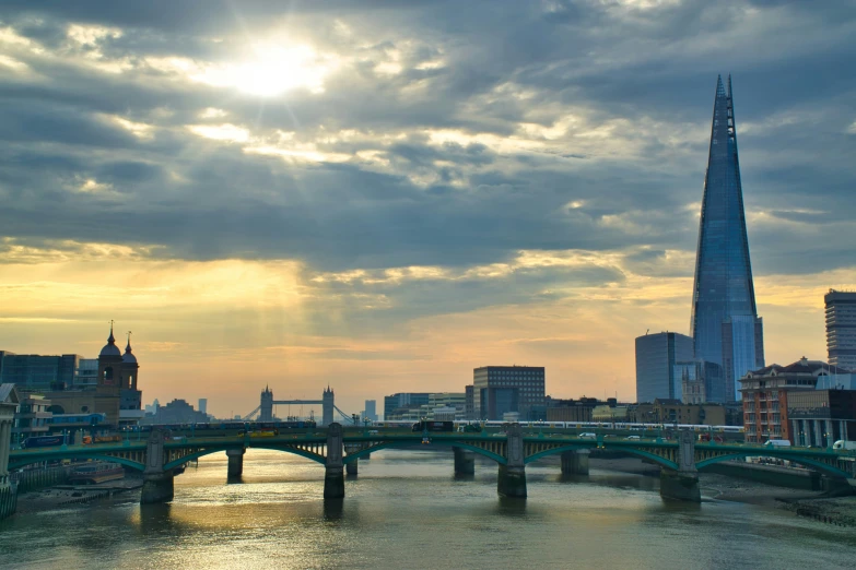 view of the sun sets over a city and a bridge