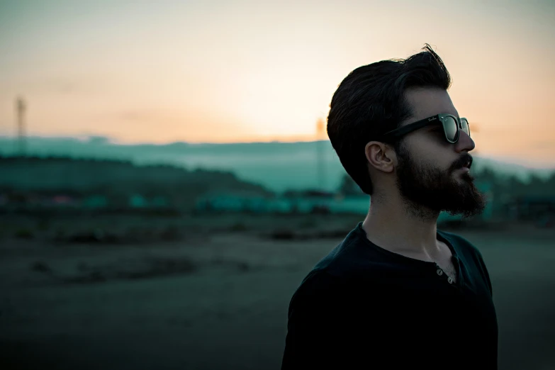 a man standing in front of a sunset