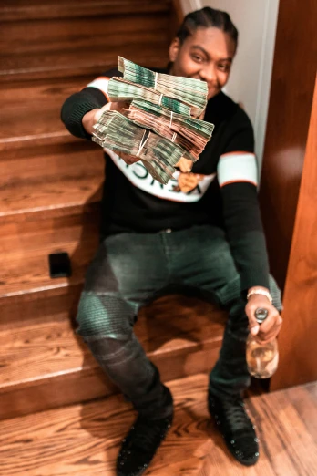 a man holding a bunch of money next to stairs