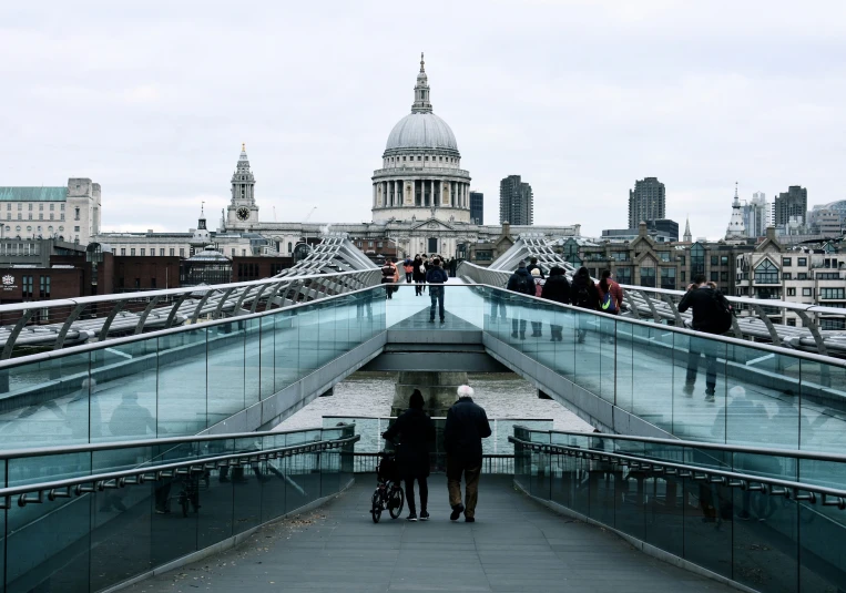 people walking across an overpass towards the city