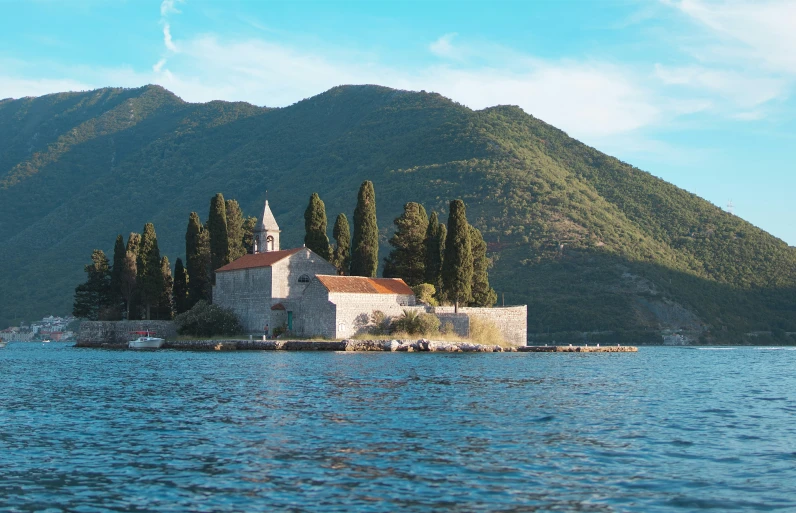 an island in the middle of a lake surrounded by trees