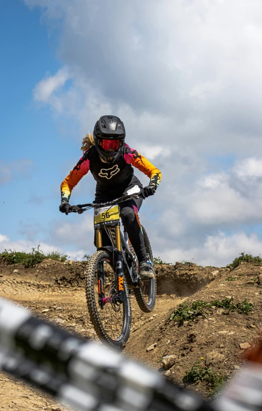 a woman is riding her mountain bike on a dirt track