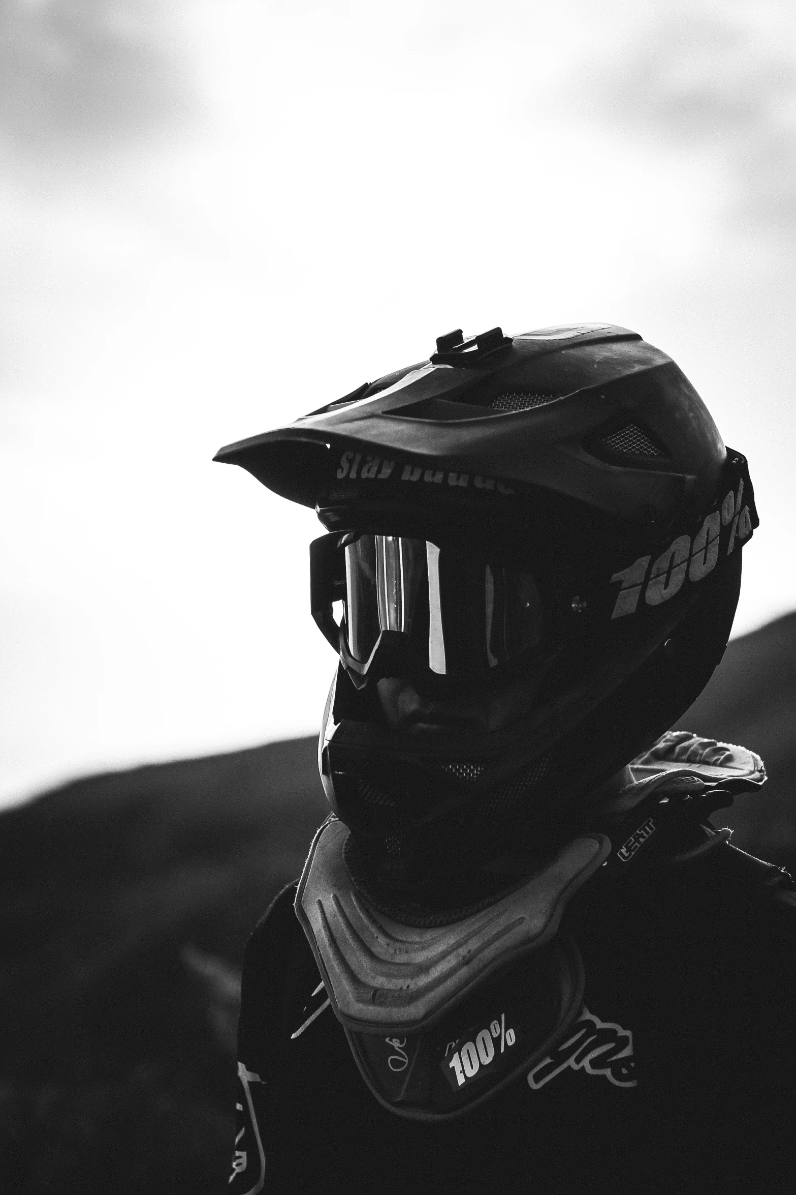 black and white po of motorbike helmet on mountain