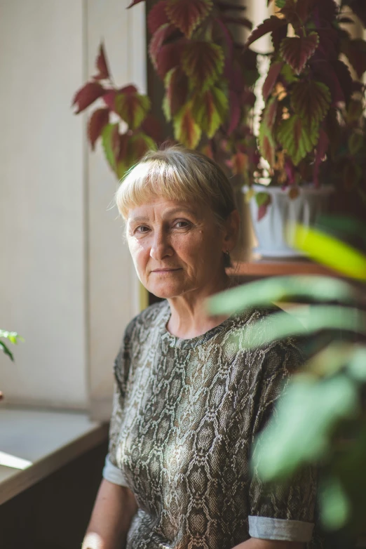 an older woman sits at the table and looks in the camera