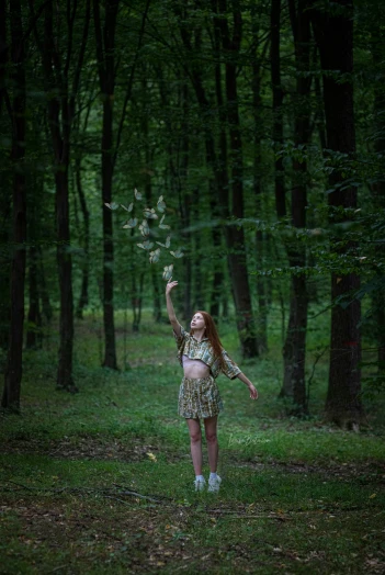 woman in a dress and umbrella throwing leaves into the air