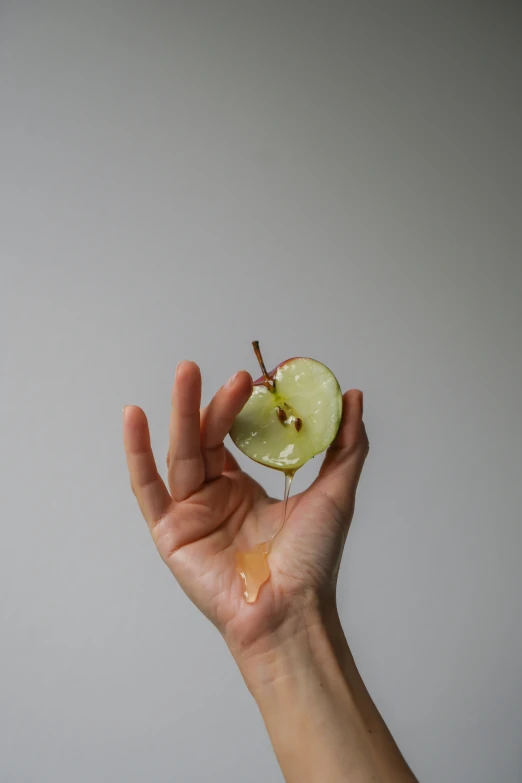 a person holding an apple with some oil on it