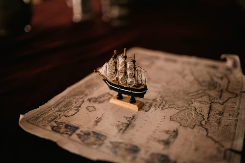 an antique sailboat on a map on a table