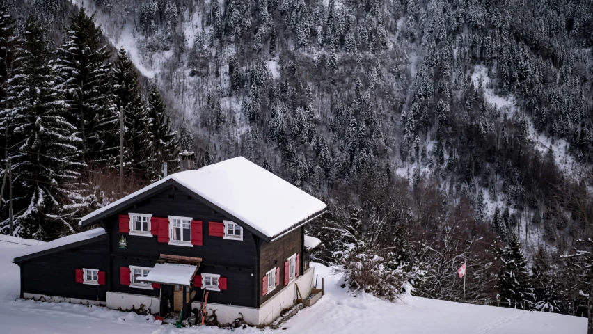 the cabin is covered in snow near a mountain