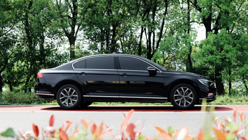 a black volkswagen sedan parked in front of trees