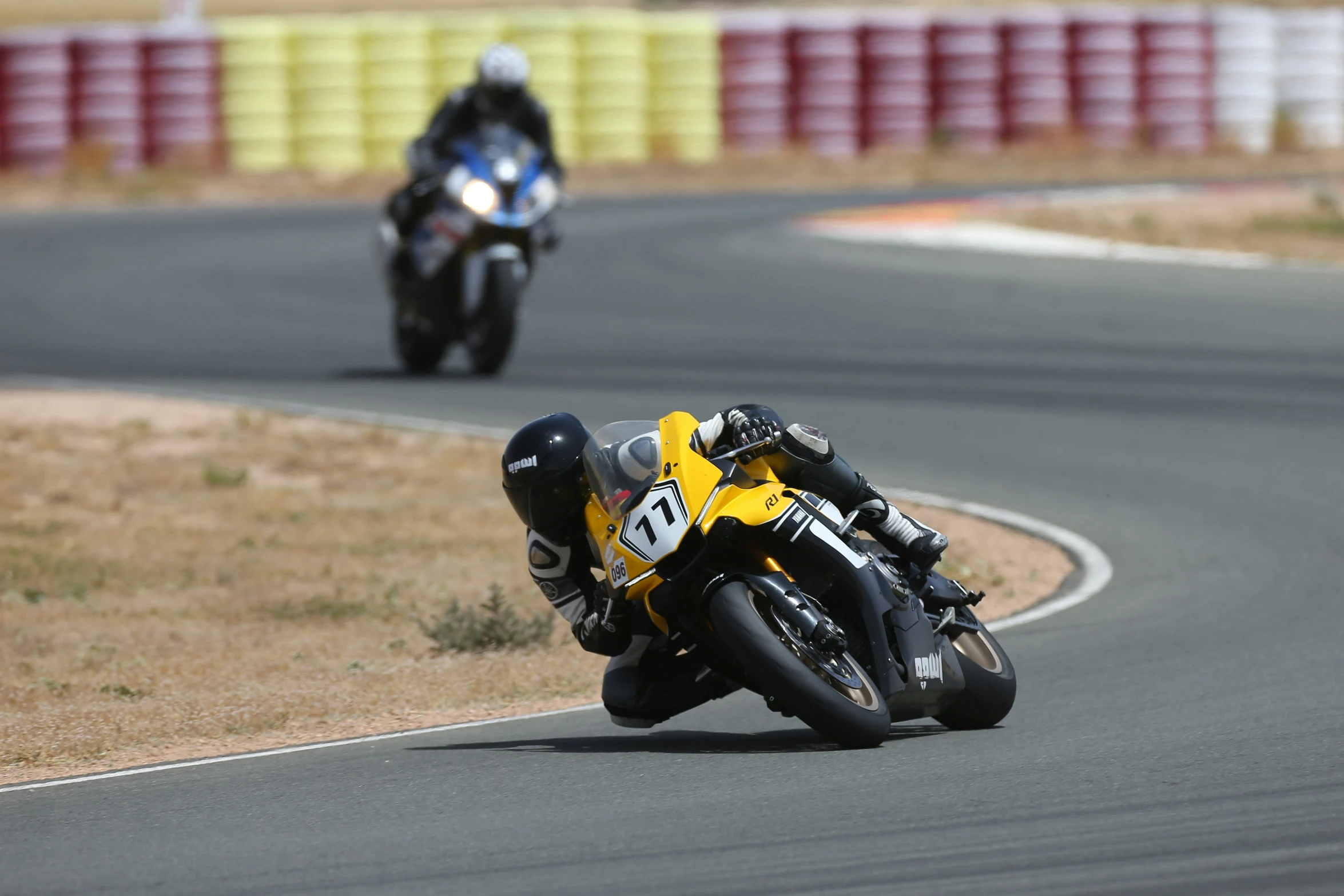 two men on motorcycles ride down a curved road