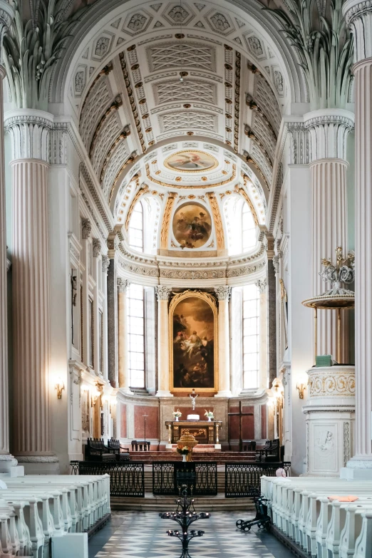 a large ornate, decorated church with pews and benches