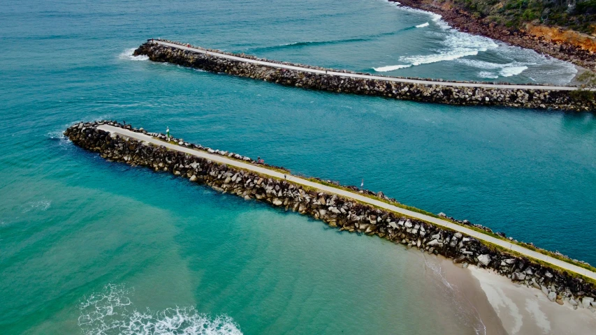 a rock wall over looking water and beach