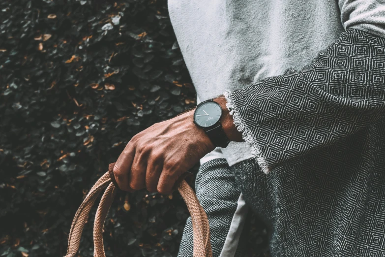 a man wearing an unoned coat and a wristwatch