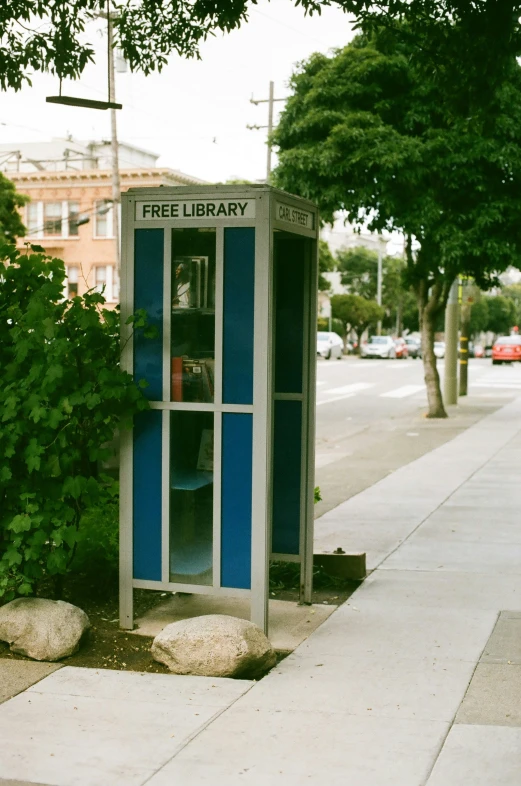 the phone booth is located on the side of the street