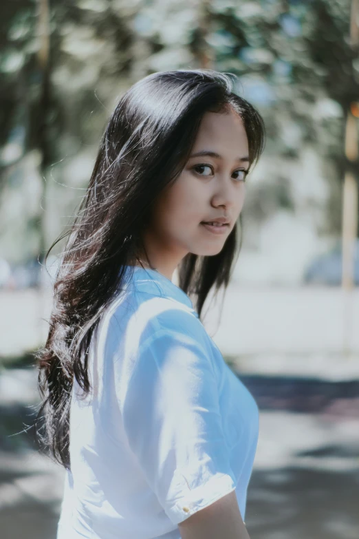 an asian woman standing on the street looking into camera