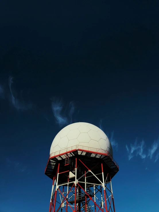 a large white ball on a red and gray structure