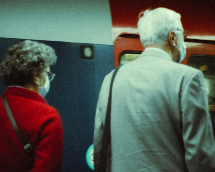 a man and a woman walk toward a public transit car