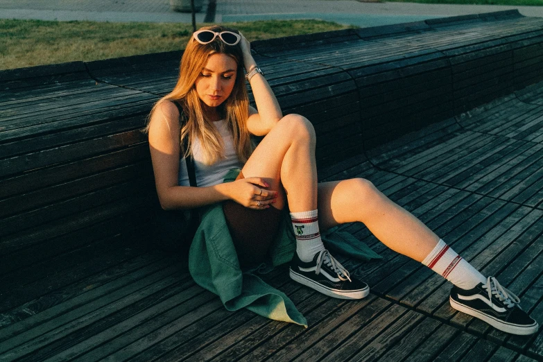 the woman is sitting down on a wooden plank