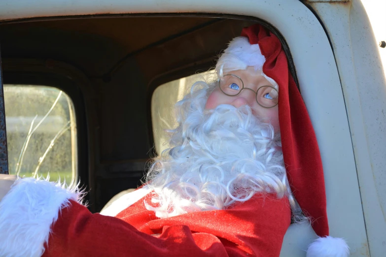a large, bearded christmas decoration is sitting in the drivers seat of a truck