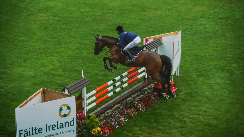 a horse and rider jumping over an obstacle