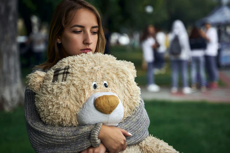 the woman is holding a teddy bear in her arms