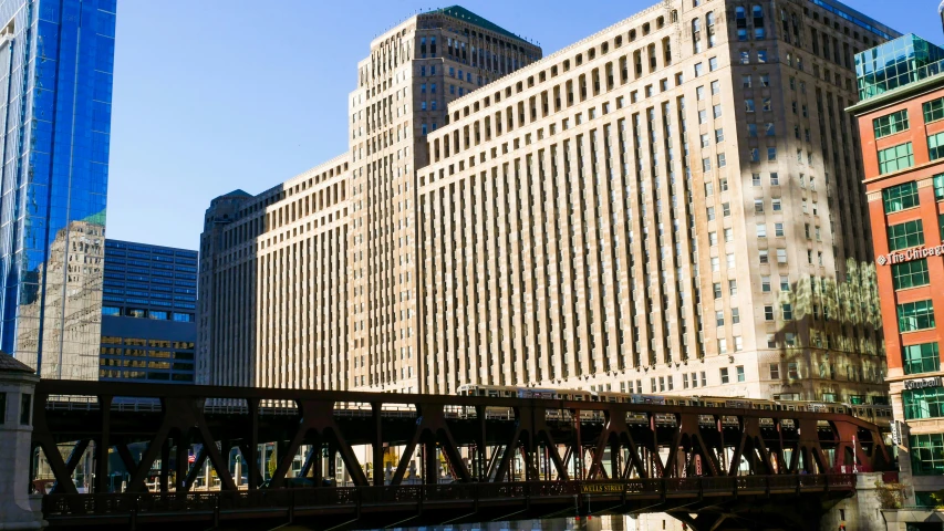 an old, iron bridge runs over the water in a city