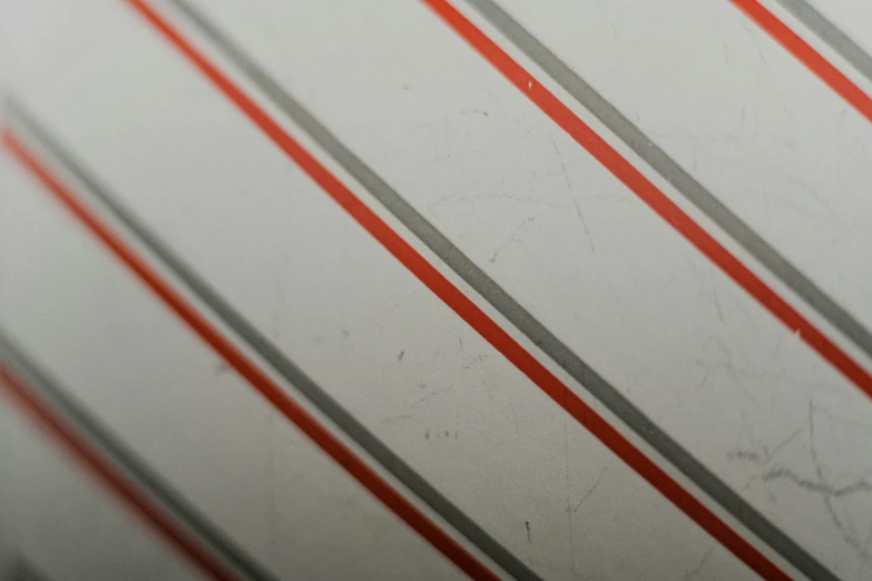 a closeup of the surface of a white surface with gray and red stripes