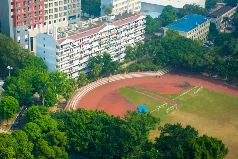 aerial view of two buildings in the background with a soccer pitch on it