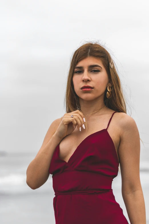 a woman with red lipstick is standing by the water