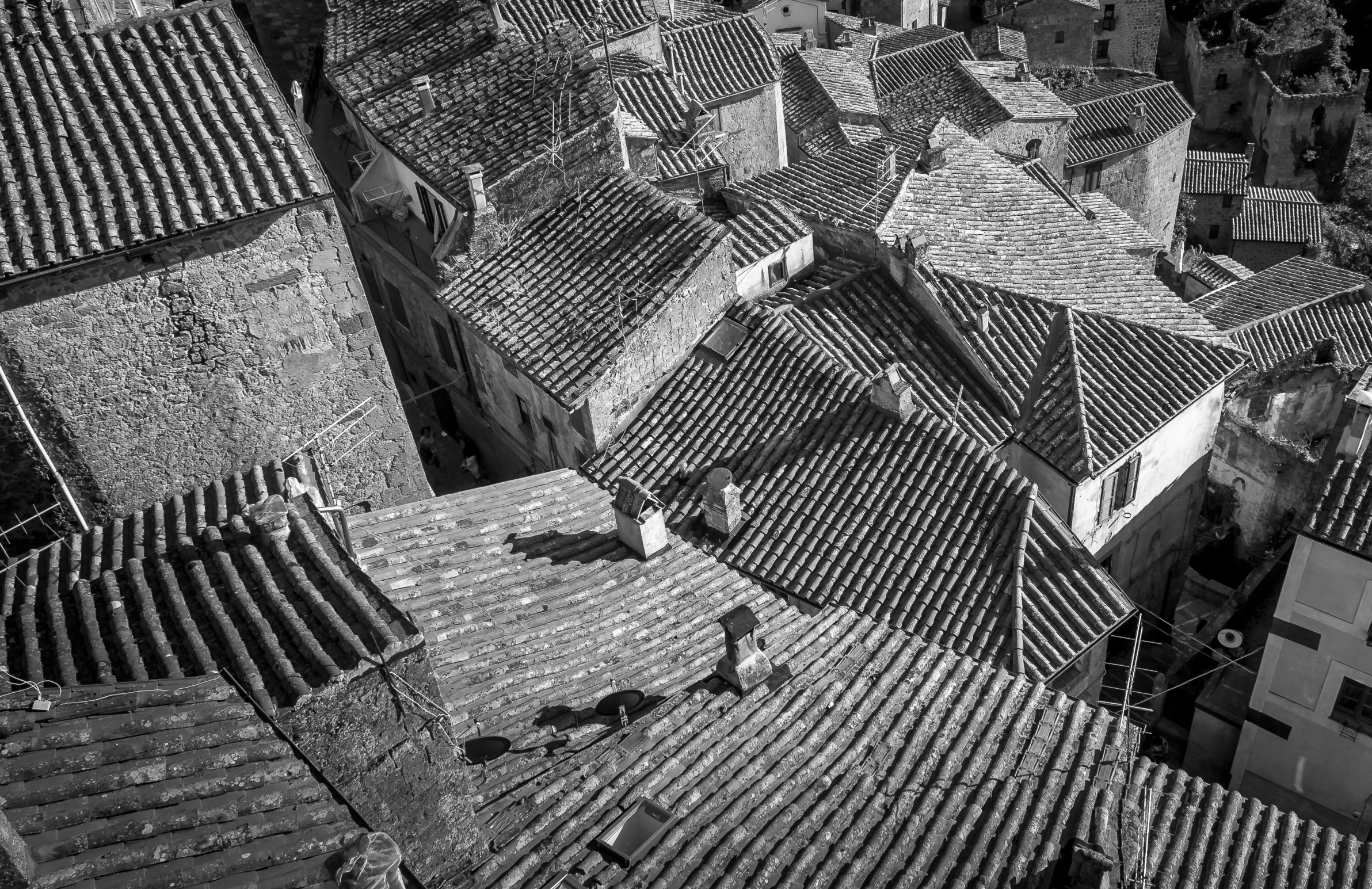 looking down at roofs of a city with a person walking on the roof