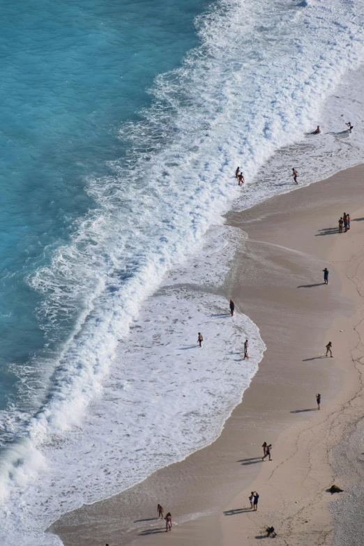 an aerial view of a beach and people playing on it