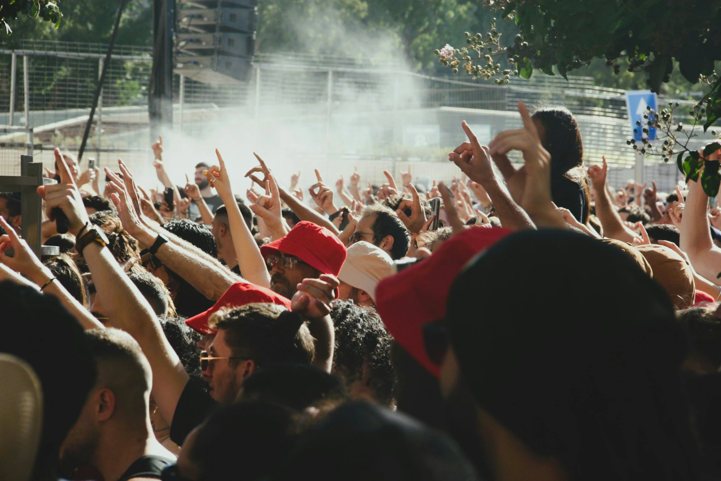 a large group of people with their hands in the air