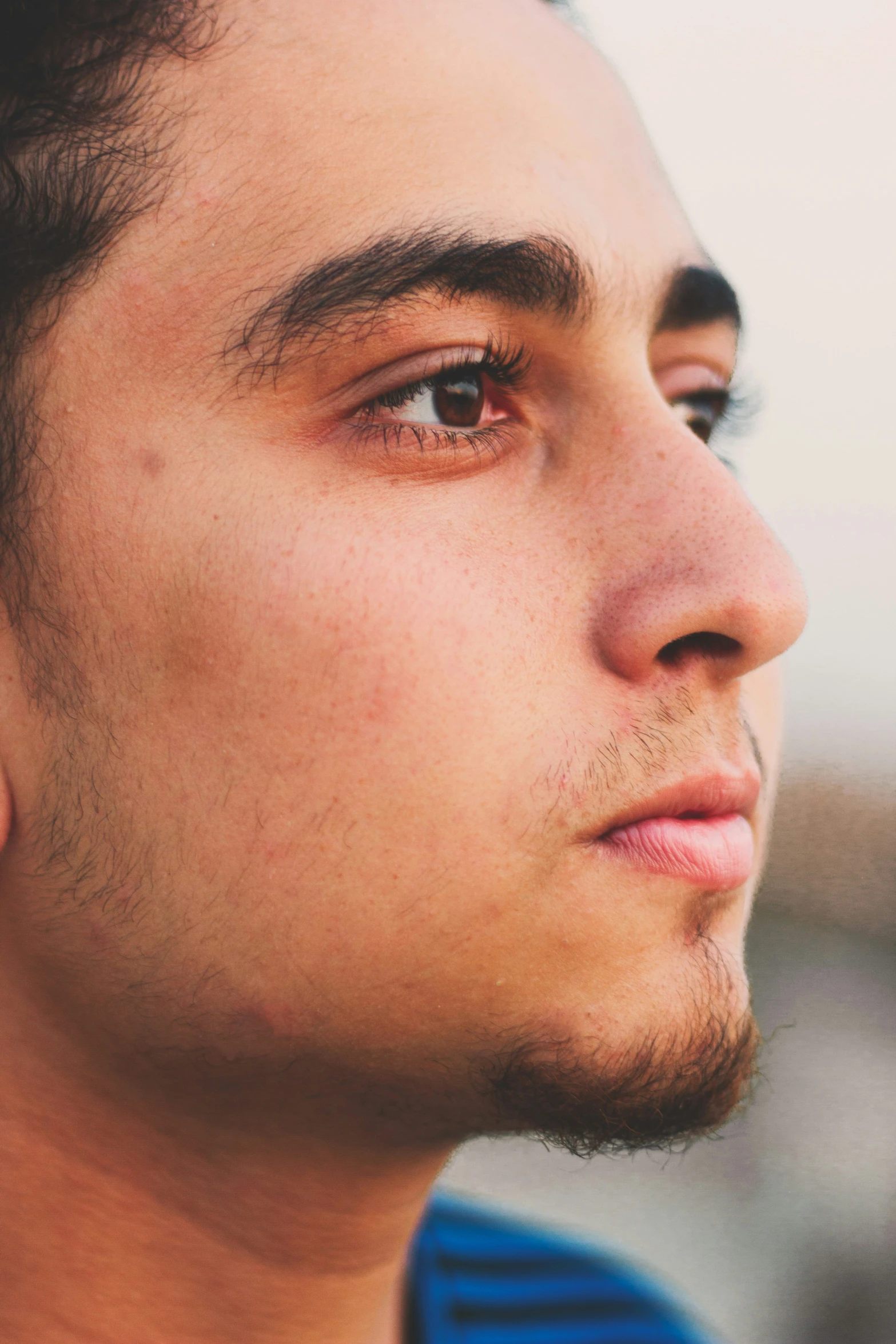 a man looks off to the side while wearing ear rings