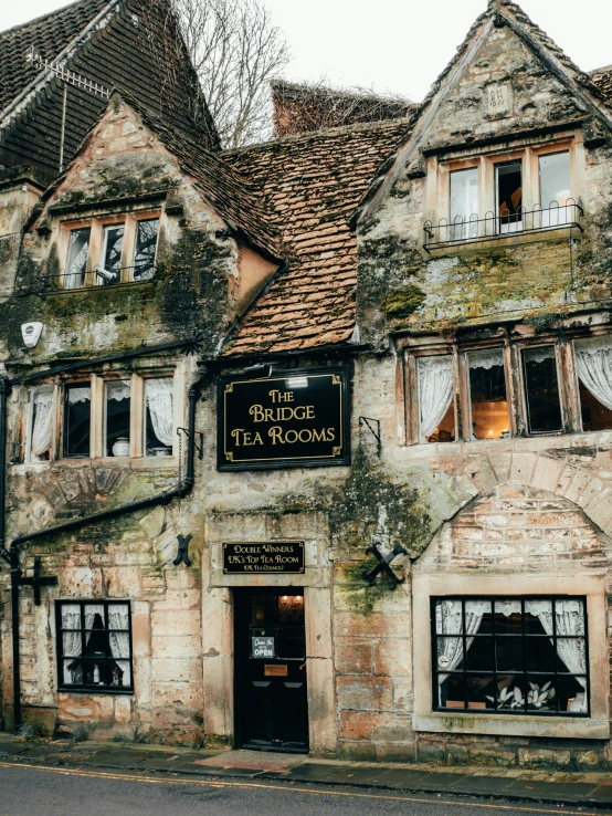 a very pretty old house with windows and a person on the front window