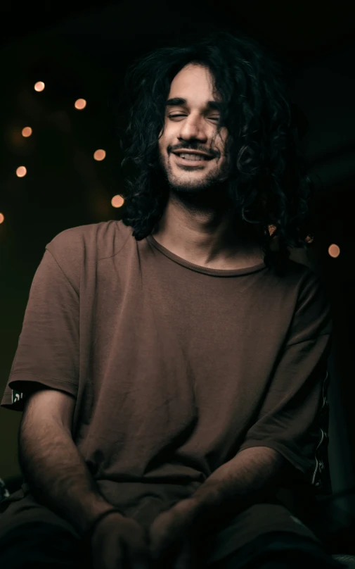 man with long hair and  smiling at the camera
