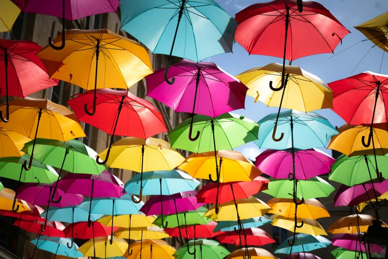 a large bunch of umbrellas hanging above a building