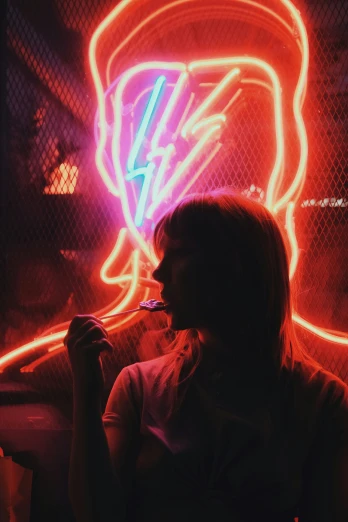 a woman sitting next to a neon sign