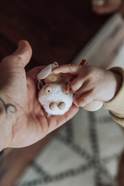 a child is holding a small white teddy bear