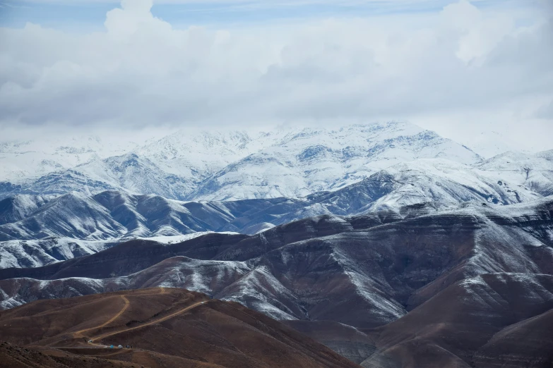 a very large snow covered mountain peak with several hills