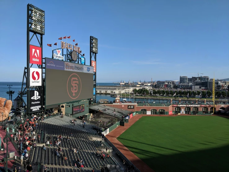 a large baseball field filled with people on a sunny day