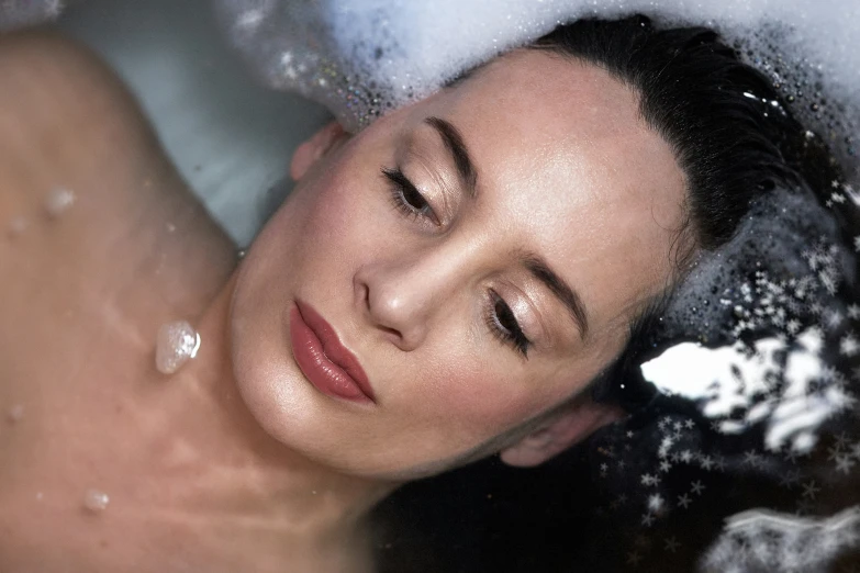 a woman taking a bath in the tub with soap on her face