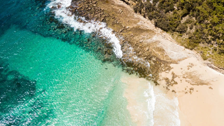 an aerial view of an exotic beach with green water