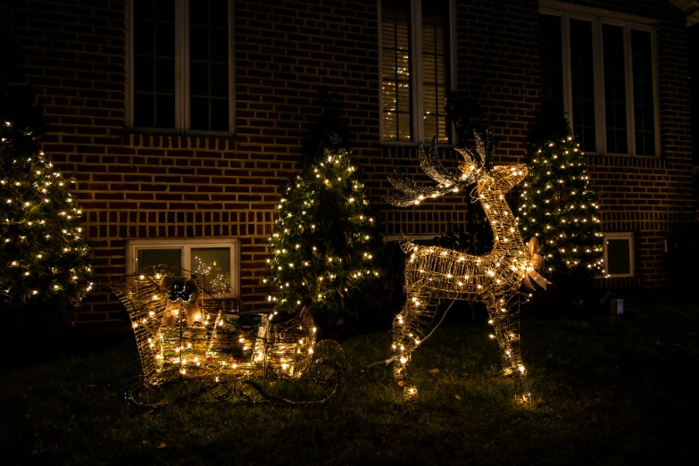 illuminated deer statues outside the house at night