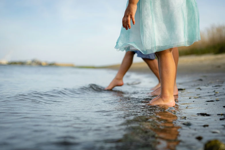 two people are wading in water near the shore