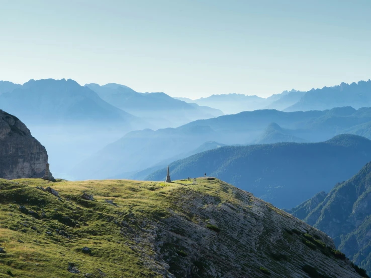 a lone man standing on the edge of a high cliff